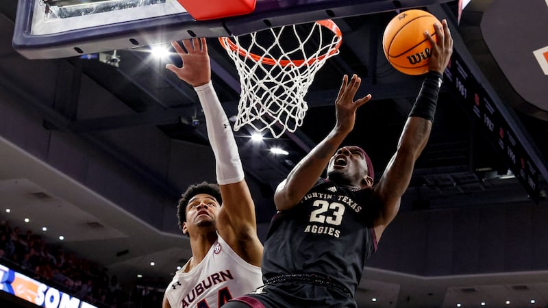 Texas A&M guard Tyrece Radford (23) shoots around Auburn center Dylan Cardwell (44) during the...