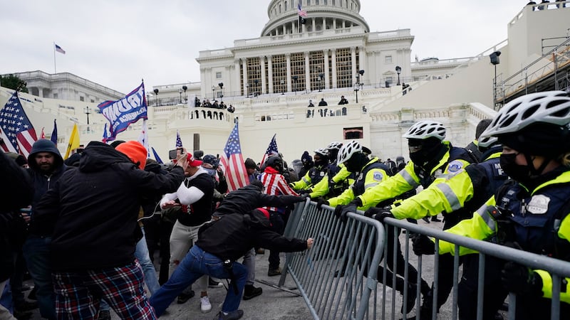 FILE - In this Jan. 6, 2021 file photo, Trump supporters try to break through a police barrier...