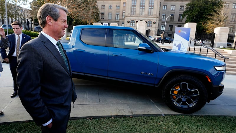 FILE -- Gov. Brian Kemp stands next to a Rivian electric truck while announcing the company's...